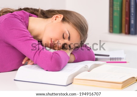 adult student girl sitting and sleeping. beautiful girl lying on desk and books