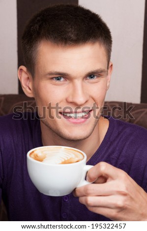 handsome young man close up picture. man drinking coffee in coffee shop