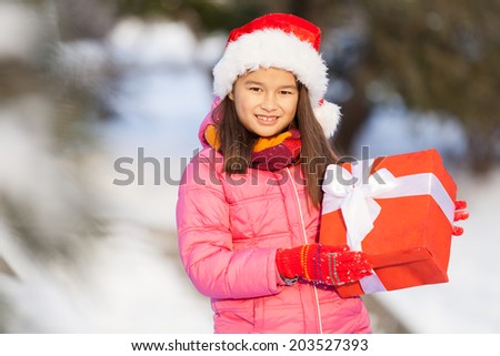 nice girl holding present outside. young girl standing outside on snow