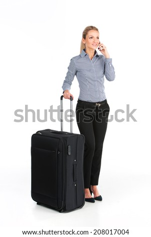 beautiful girl standing with big luggage. young girl talking on phone on white background?