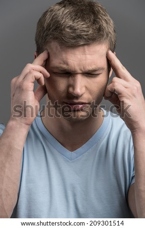 Stressed business man with headache isolated. Worried young man suffering from headache