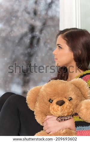 Portrait of pretty girl in sweater holding toy. pretty girl holding teddy bear
