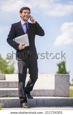 businessman walking on stares outside and smiling. handsome guy talking on phone and descending