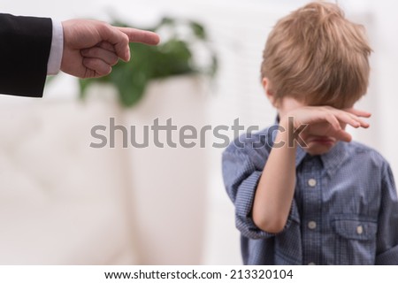 Strict father discipline naughty son. Isolated on white background boy wiping tears