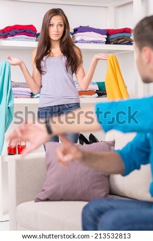 young man showing time to his girlfriend. wife dressing up clothes and getting ready