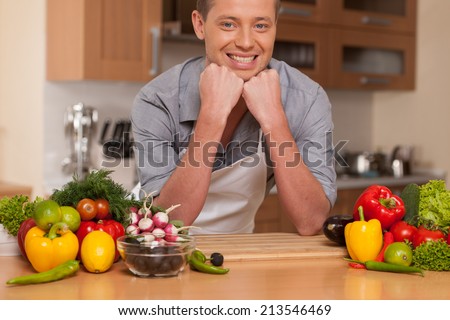 Caucasian man leaning on chopping board. guy preparing food at kitchen counter