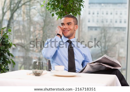 young handsome business man talking on phone. cool guy holding newspaper and smiling