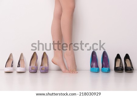 Woman having hard time choosing. Beautiful woman legs, isolated on white