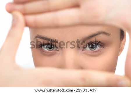 Smiling woman showing frame by hands. Happy girl with face in frame of palms