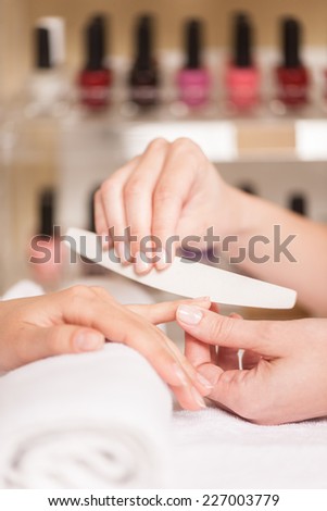 Close-up of beautician hand filing nails of woman in salon. manucurist women sitting in spa salon and relaxing