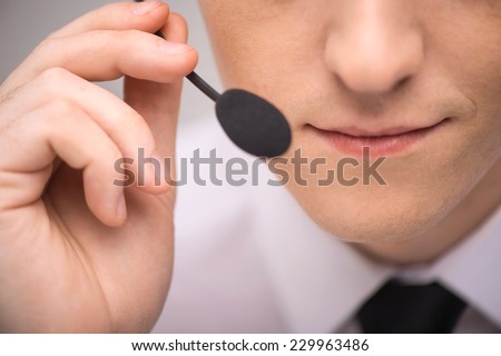 handsome technical support operator working on computer. male mouth with headset portrait holding mic