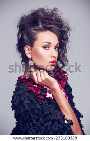 Fashion photo of beautiful lady in elegant evening dress. pretty girl standing on grey background wearing jewelry
