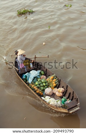 Can Tho, Vietnam - APRIL 2: Woman on boat in conical hat floating down Mekong river at Can Tho Floating Market, Can Tho, Mekong Delta, Vietnam on April 2, 2014.