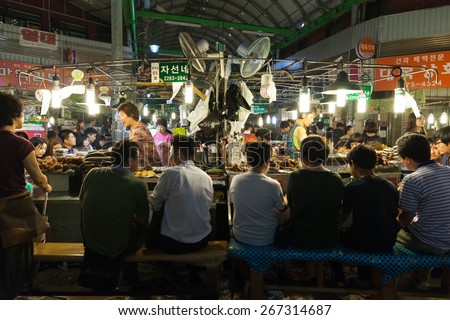 Seoul, Republic of Korea - 14 August 2014: People eating at the food stalls at the traditional Gwangjang street market on August 14, 2014, Seoul, Korea.