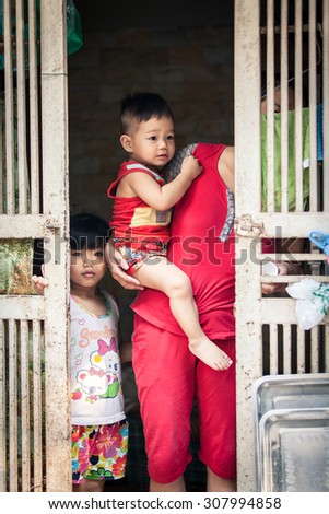 Hanoi, Vietnam - April 26, 2014: Portrait of  Vietnamese family at the entrance of their home on the street of Hanoi, Vietnam on April 26, 2014.