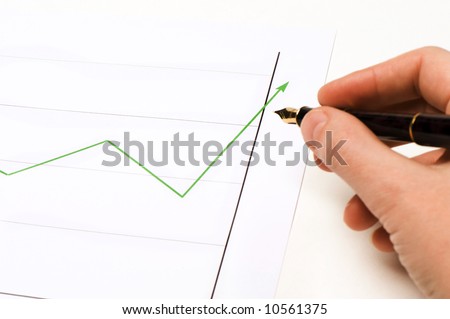 graphics showing a green line going up. Someone\'s hand is holding a pen and is following the lign. Success.