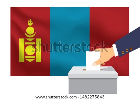 Male hand puts down a white sheet of paper with a mark as a symbol of a ballot paper against the background of the Mongolia flag. Mongolia the symbol of elections.