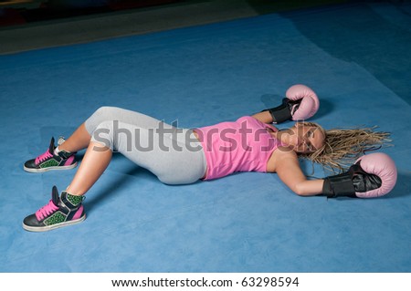 Pretty female boxer knocked out laying on the floor