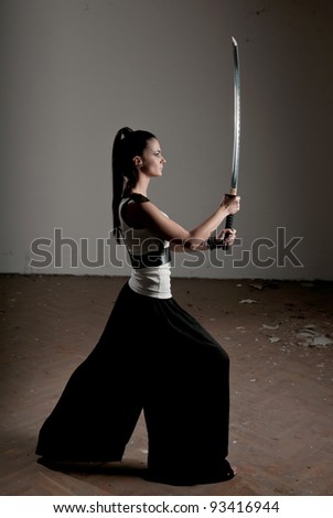 Beautiful woman holding a long shining steel ceremonial sword
