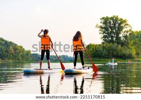 Similar – Image, Stock Photo Woman with paddleboard on shore in sea