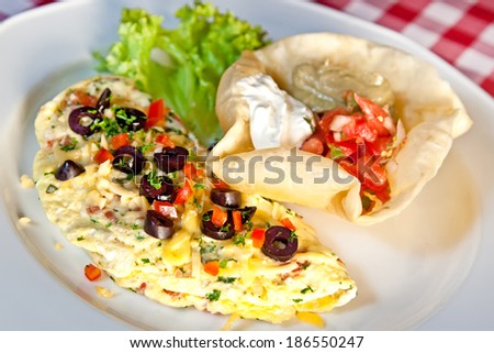 Omelette with greens, salsa, cheddar cheese, olives and sour cream
