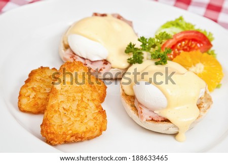 Eggs Benedict with two halves of an English muffin, balyk, eggs, and Hollandaise sauce