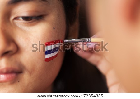 BANGKOK, THAILAND:13 January: Unidentified lady with Thai national flag painting on her face at anti-government protest on January 13, 2013, the first day of Bangkok Shutdown in Silom area.