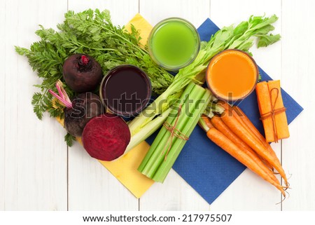 Vegetable juice with beet carrot and celery on white wood background