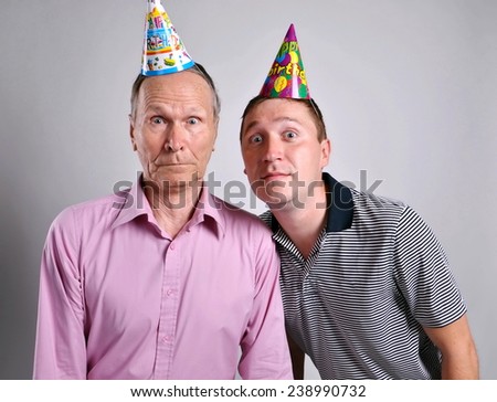 Two surprised man. excited faces in party hats
