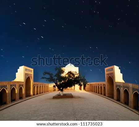 Arabian night. Night sky with star trails above Kolon mosque in Bukhara, Uzbekistan.
