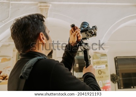 Similar – Image, Stock Photo Man shooting building facade with smartphone in downtown