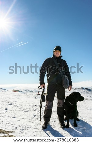 Man with dog on snowy mountains plateau , close-up