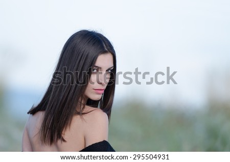 Portrait of a beautiful woman's back side, looking straight at the camera