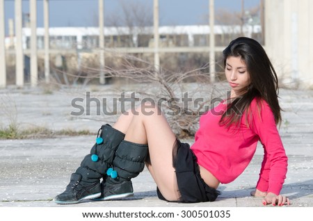 Young lady with boots and very short skirt sitting cross-legged