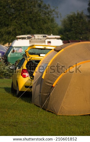 Tents and cars in an outdoor camping site staying here overnight