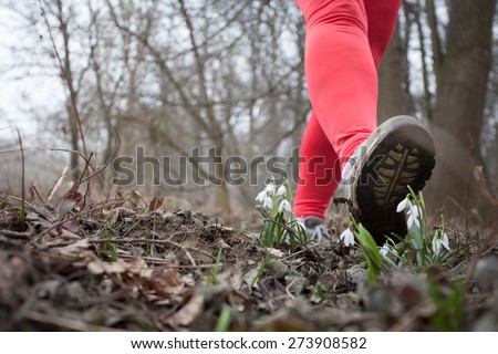 Natural environment protection concept: Man treads on flowers in the spring forest, destroying it.