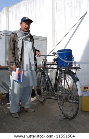 Afghan volunteer polio vaccinator with polio vaccine on bicycle