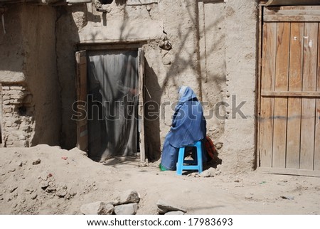 Afghan woman sits on chair