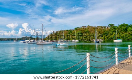 Yachts on moorings in the tranquil waters of Muelle Bay, Puerto Galera, Philippines. Shot from the promenade of a public park. Zdjęcia stock © 