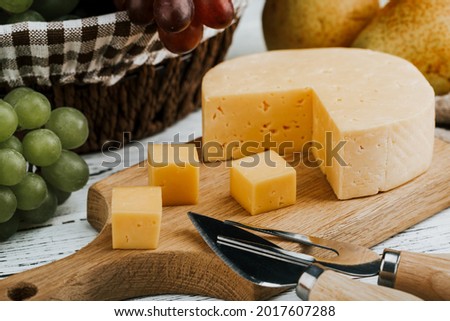Cheese dish with organic cheeses, fruits, nuts on a wooden background. Delicious cheese snack