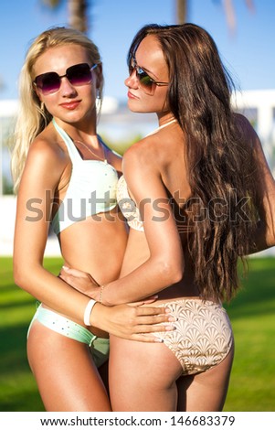 Two fashion models posing on the beach