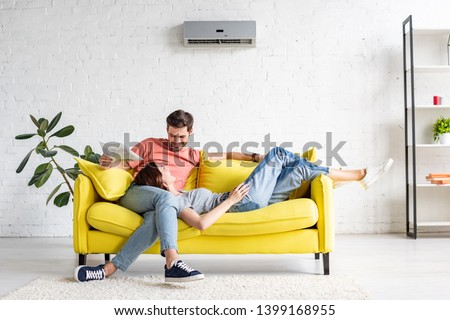 Similar – Image, Stock Photo Young couple resting on cozy sofa at home