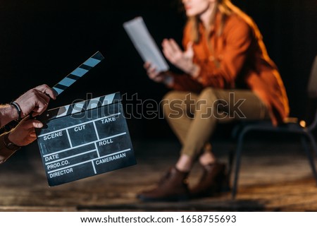 selective focus of actor with clapboard in front