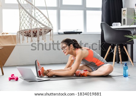 Similar – Image, Stock Photo Focused sportswoman hanging on bar while working out in gym