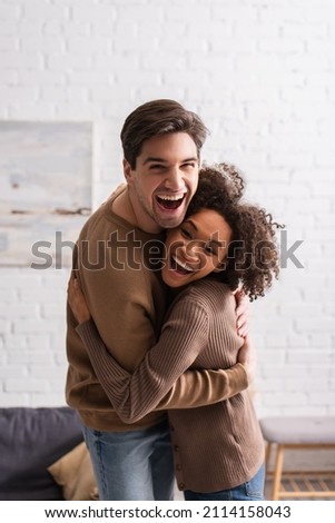 Similar – Image, Stock Photo Positive multiethnic couple embracing on street