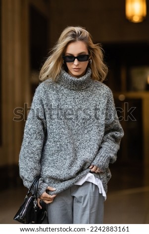 Image, Stock Photo Woman in black winter jacket and cap looking at black roadster on parking lot