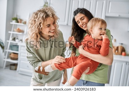 Similar – Image, Stock Photo Cheerful couple of lesbian women embracing at home