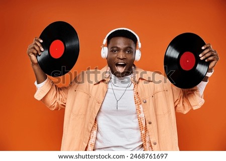 Image, Stock Photo Man holding vinyl record. Vintage music style. Rock style. Male wearing black jacket holding black disc standing on dark background. Retro music