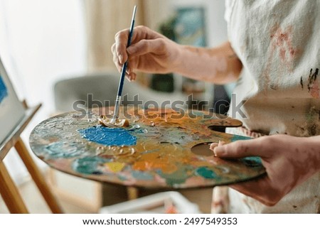 Similar – Image, Stock Photo Focused artist blending paints in palette