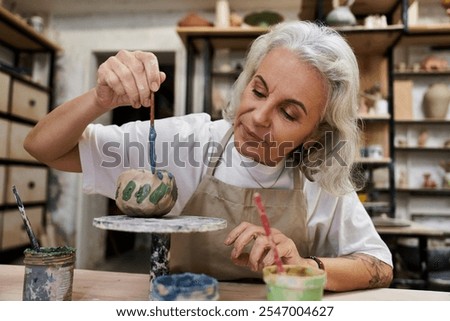 Similar – Image, Stock Photo Craftswoman painting a bowl made of clay in art studio